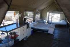 De inventaris Een Serengeti tent lodges is ingericht met De keuken wordt gevormd door een keukenblok met een werkblad en laden, een koelkast, een magnetron en een koffiezetapparaat.