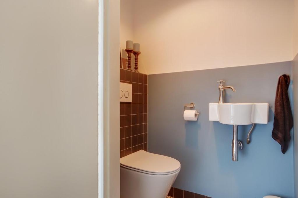 De hal geeft je toegang tot de moderne toiletruimte met wandcloset en fontein en de trapopgang