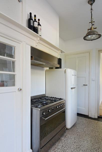 Karakteristieke semi-open keuken met een keukenblok met een houten aanrechtblad, spoelbak en onderkastjes en