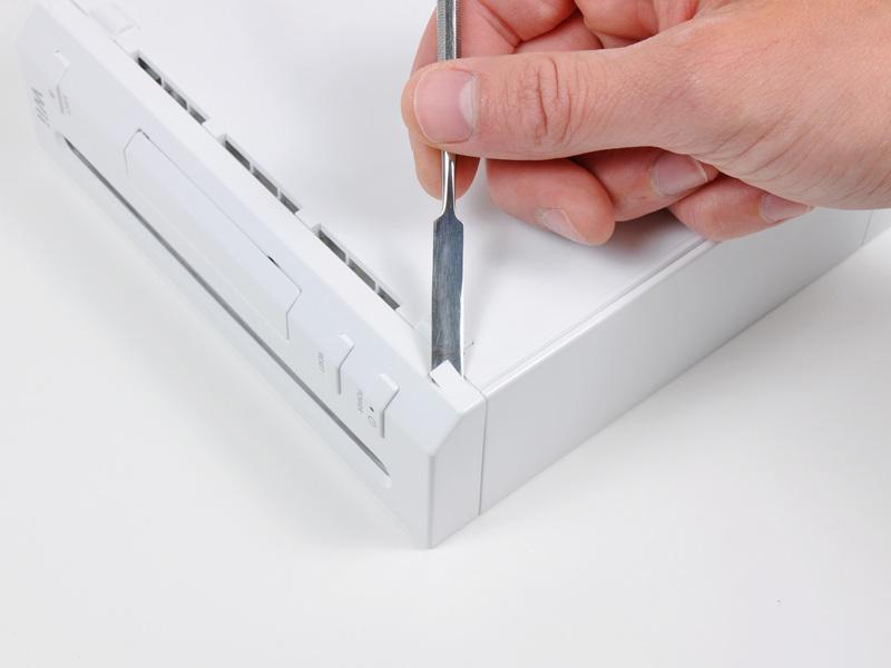 Stap 1 Faceplate Gebruik een metalen spudger het verwijderen van de witte plastic schroef dekt vast aan de kleine letters in de buurt van de voorkant van de