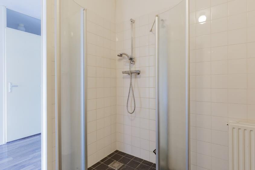Daarnaast is de badkamer voorzien van het navolgende: een ligbad met handdouche een wastafelmeubel met een spiegel met