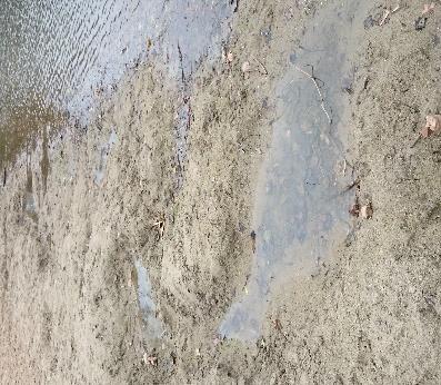 De pomp waarmee water door de speelgoot wordt gepompt en de zwemzone doorspoelt, stond uit. De gebruikerssporen van het zwemseizoen waren nog duidelijk zichtbaar aan de gegraven gaten in het zand.