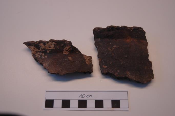 Fig. 22 en 23: Randscherven met vingerindrukken en bijzetpotje met rand. 4.2.3 Romeins In spoor 141 werd een ruwwandig bodemfragment gevonden.