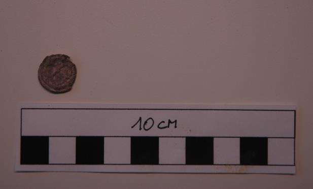 1 Lood Het eerste voorwerp is een lakenloodje, dat in spoor 23 werd gevonden. Het is rond, heeft een diameter van ongeveer 1,4 cm en is langs twee kanten beslagen.