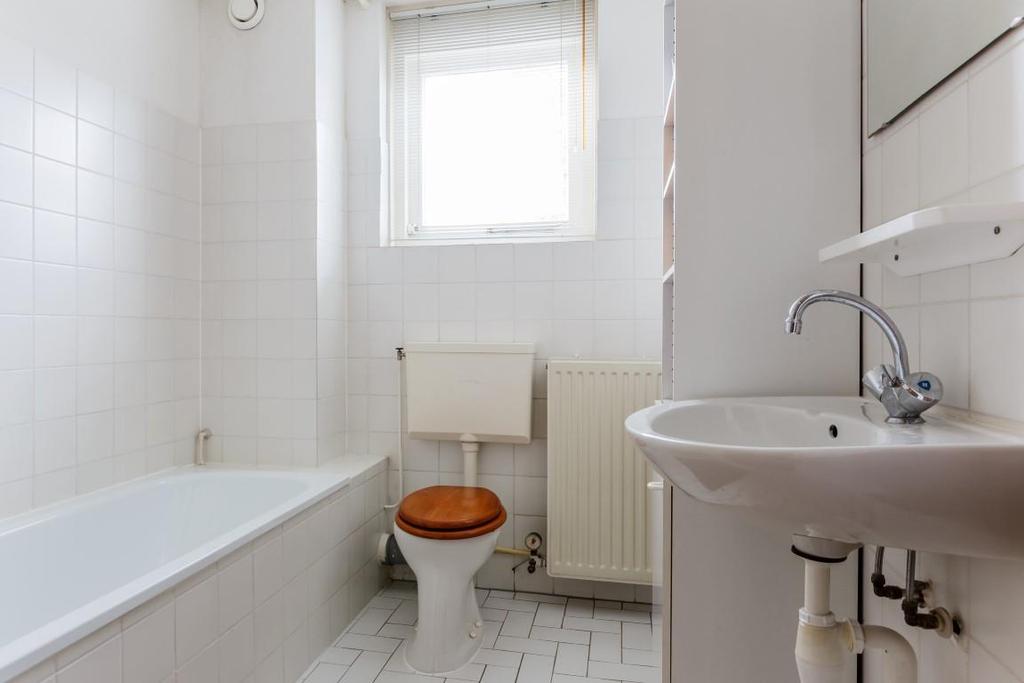 De badkamer: De nette badkamer is betegeld in een neutrale kleurstelling en voorzien van: een ligbad met douchegelegenheid