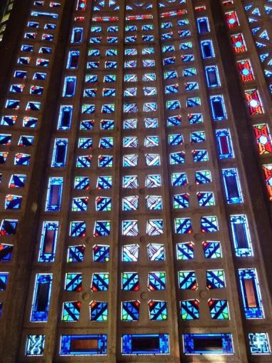 King s College in Cambridge, bestaan de buitenmuren eenvoudig uit een rastervormig scherm met open panelen van voorgestort beton, die met gekleurd glas zijn opgevuld.