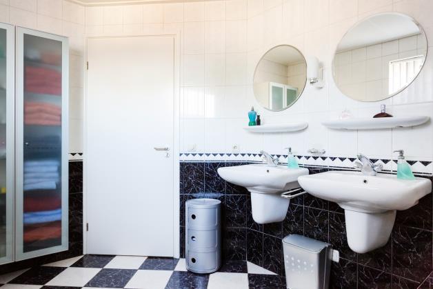 De tweede badkamer is in dezelfde stijl afgewerkt als de eerste badkamer en is voorzien van een douchecabine en een wastafel.