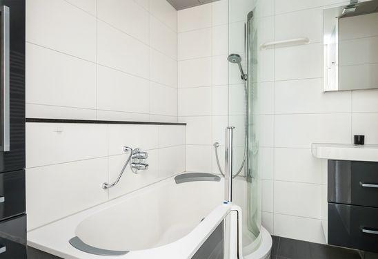 De badkamer is voorzien van een bad/ douche combinatie met