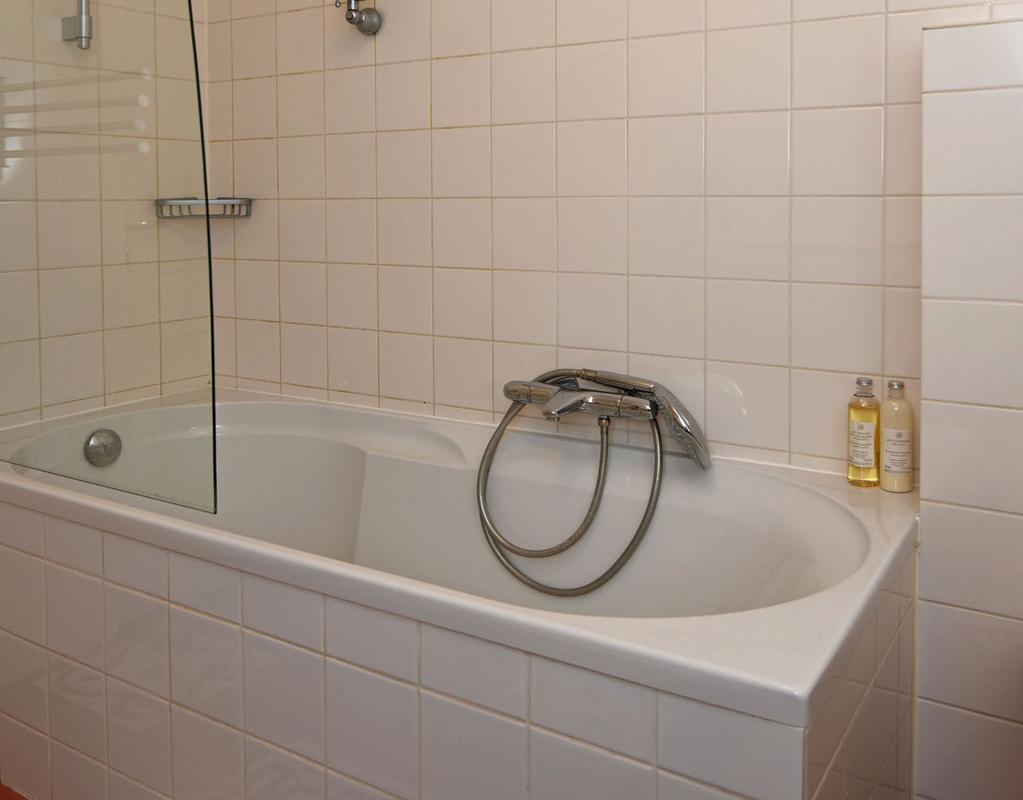De badkamer is voorzien van een ligbad/douche met glazen wand, een