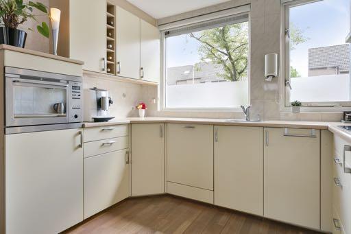 De open keuken is bereikbaar vanuit de woonkamer en heeft een houten vloer.