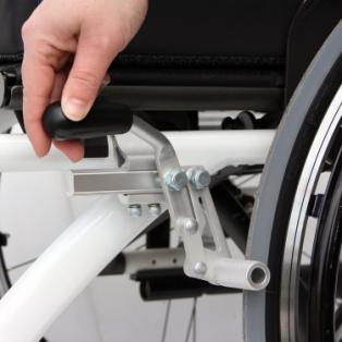 de klik hoort die bevestigd dat u de rolstoel op de parkeerrem heeft gezet (foto 27).
