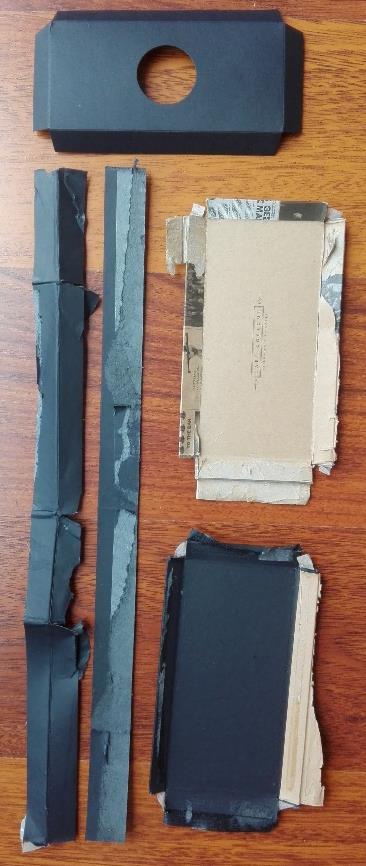 Buitenkant: zwarte herenfiguur Assemblage - Gelijmd - Plakband aan de hoeken Extra s - Mousse - Geflocked materiaal (plakte op de mousse) - Verbinding doosje aan deksel (bruin gekleurd papier) Figuur