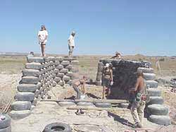 Bladzijde 2 De bouw van een earthship De gebruikte autobanden worden met aarde gevuld en aangestampt zodat ze een erg stevige massa vormen.