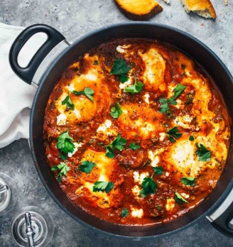 Shakshuka hoofdgerecht 2 à 3 personen 6 eieren 3 el olijfolie 1 rode paprika, in blokjes 1 ui, snipperen 1 blik tomatenblokjes à 400 gr 2 tenen knoflook 1 tl paprikapoeder 1 tl komijnpoeder 1 snuf