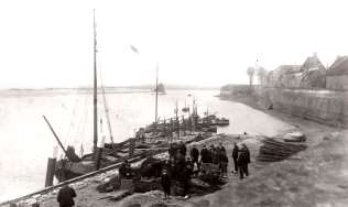 Een prachtige oude foto van Woudrichem uit vroeger tijden met zalmschouwen die liggen afgemeerd aan de visvlotten. Vakantietijd!