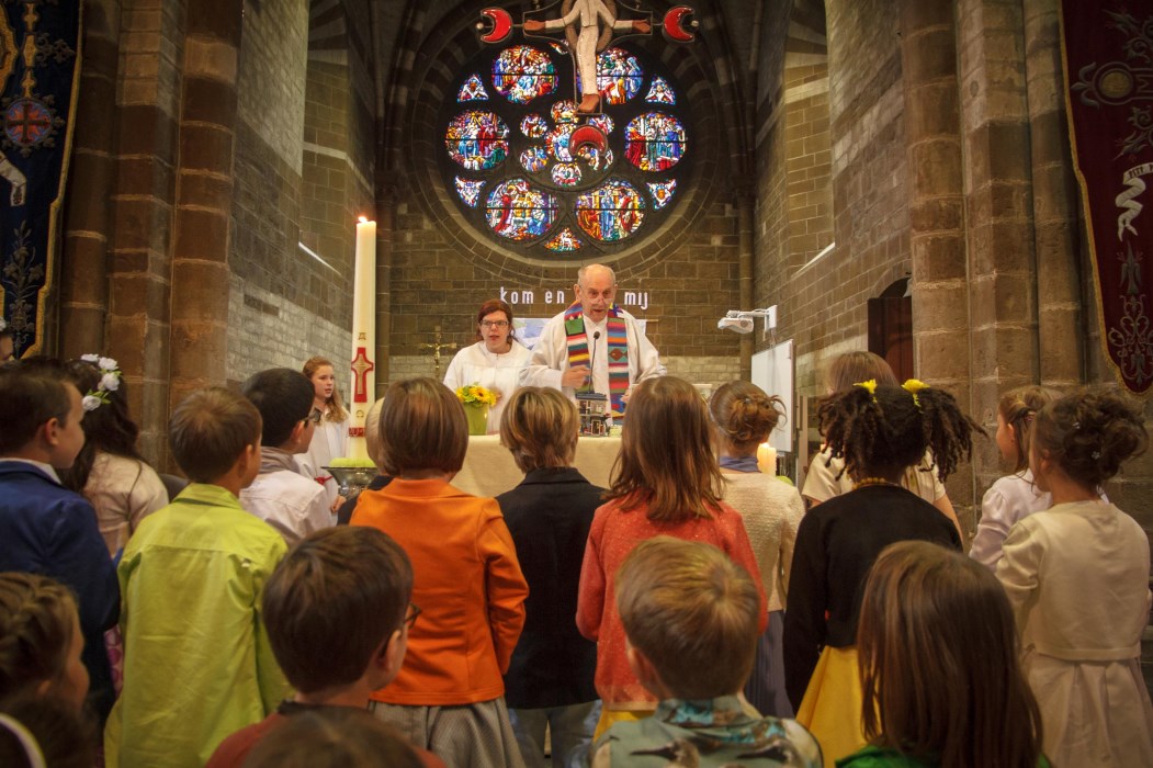 SFEERFOTO S VAN DE EERSTE COMMUNIEVIERINGEN EEN VOLLE EN PRACHTIG VERSIERDE KERK VOL BLIJE EN ENTHOUSIASTE MENSEN