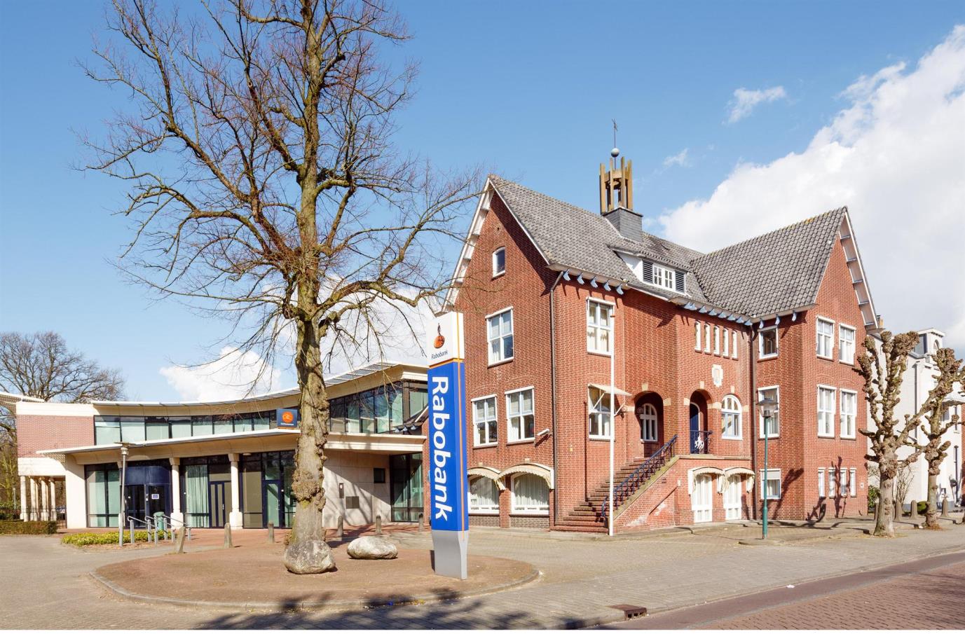 Een voormalig kantoorgebouw van Rabobank, bestaande uit twee delen, gesitueerd tegenover de dorpskerk, centraal in het dorp Ossendrecht.