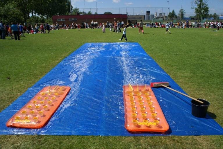 2. Buik glijden De kinderen worden naast elkaar opgesteld terzijde van de startpion. De beide luchtbedden liggen klaar aan het begin van het glijzeil.