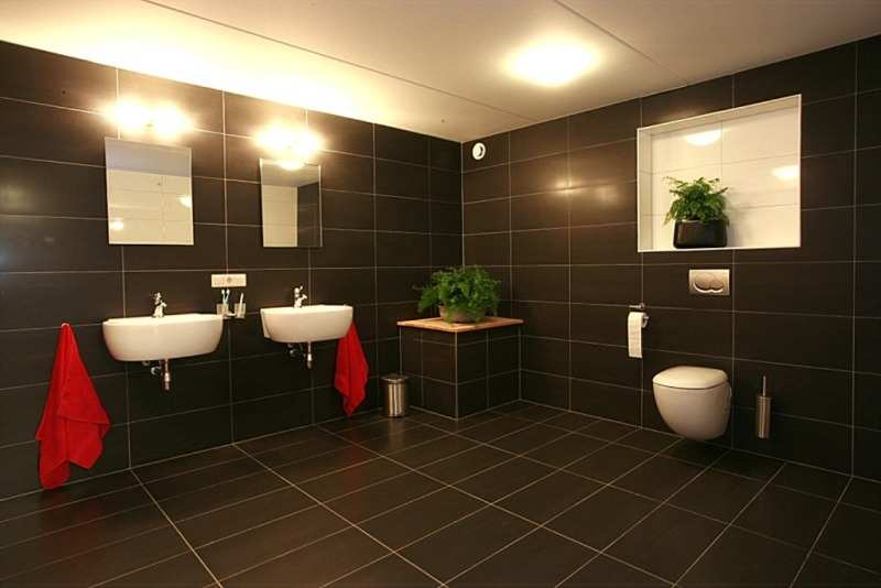 Onderverdieping: Vaste trap naar een grote open ruimte met aansluitend een ruime badkamer met douche, dubbele wastafel, toilet en
