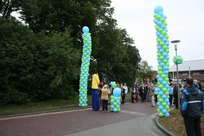 BALLONZUILEN De ingang van een straat of pand wordt afgesloten met 2 grote ballonzuilen die naar elkaar worden gebogen. In het midden worden ze met nylondraad aan een klein ballonzuil vastgemaakt.