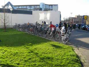 Fietsbalans -2 Gouda Fietsparkeeronderzoek 13 Totaal 1 Een middelgrote winkel in een woonomgeving met veel flats. Fietsen waarvoor geen plaats is in de fietsenklemmen worden tegen de winkelpui gezet.