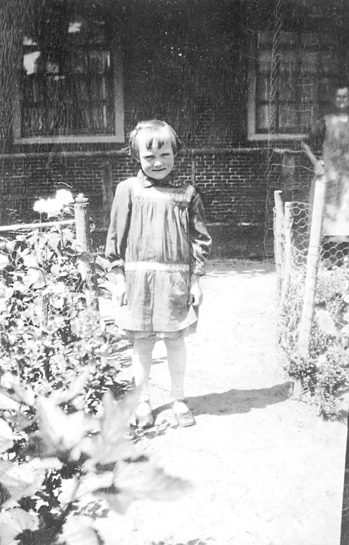 Dien van Kempen (geb. 1927), gefotografeerd in 1933 op het tuinpad van de woning van haar grootouders op Wakkerendijk 224. Op de achtergrond opoe Hanna Kroeskamp-van Lunteren. V.l.n.r. Dien Loep-van Kempen (geb.