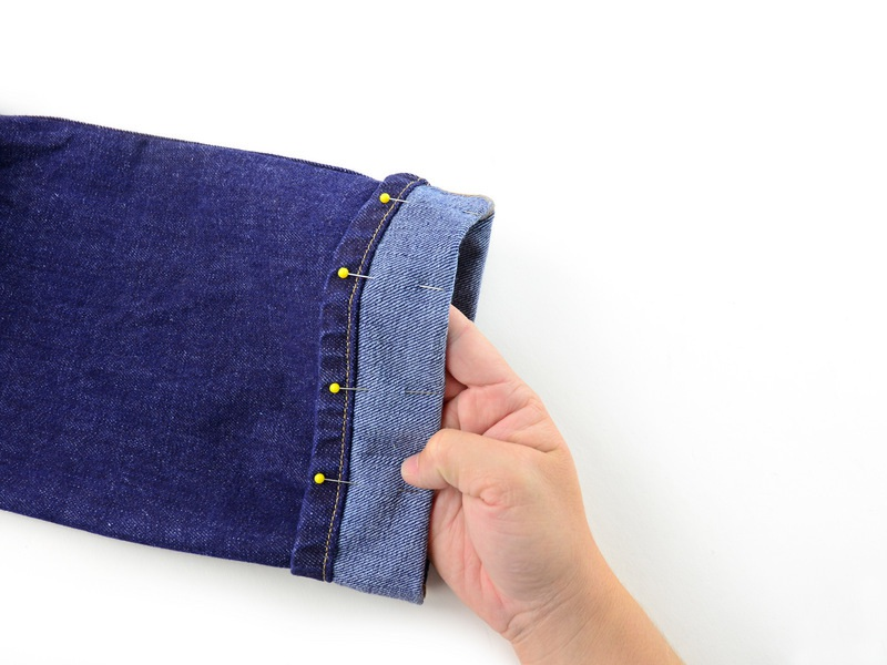 Stap 7 Vouw de manchet van de broekspijp tot aan de lijn van de pinnen te voldoen, passend bij de rand van de jeans met de rij van pinnen.