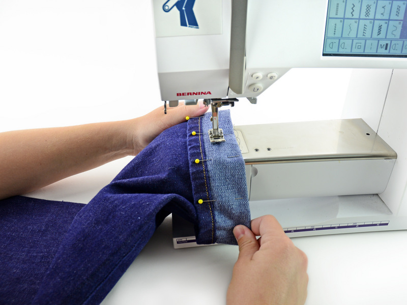 Stap 8 Stel uw naaimachine met schroefdraad die overeenkomt met uw jeans en een heavy-duty / denim naald. Plaats de broekspijp in de naaimachine, schuiven van de manchet om de arm van de naaimachine.