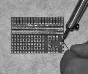 Plaats de SMD diode met een pincet op het inbouwvlak en houd het daar, terwijl u het met de solbeerbout vastzet. Verhit daarvoor voor een seconde de diode aan de zijkant met de voorvertinde pad.