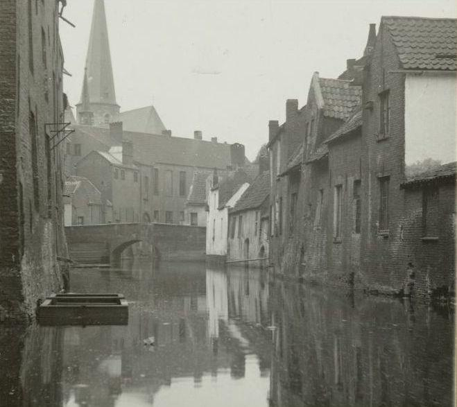 Achter de huizen links bevond zich de Houtbriel en achter de huizen rechts de Ijkstraat waar de schepen geijkt werden. In het midden ziet men de verdwenen St-Jansbrug.