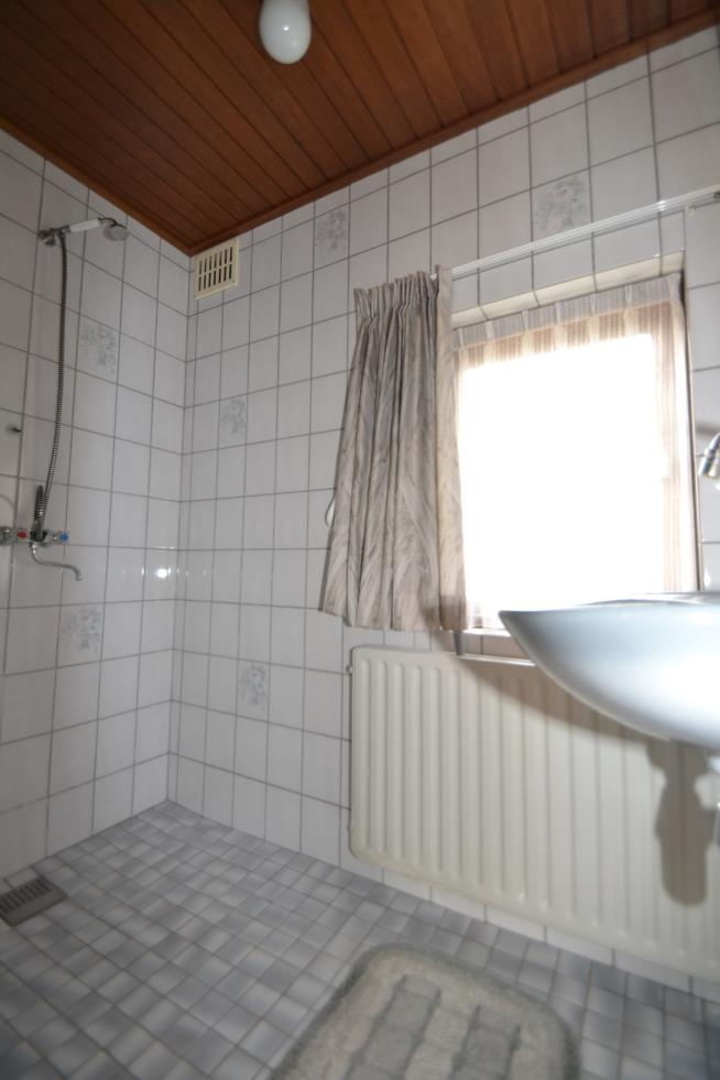 De badkamer is ca. 1.15x2.00 m. en is volledig betegeld. De eenvoudige inrichting bestaat uit een vaste wastafel en een ruime inloopdouche. Het plafond is afgewerkt met schrootjes.