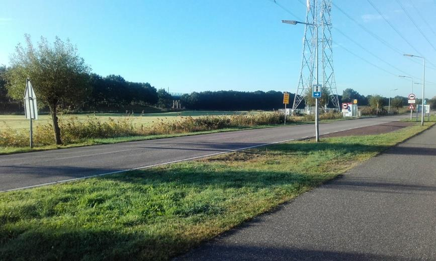 Foto 5 Foto 5: Zicht op de IJsselmeerweg langs het weiland, met links de spoordijk.