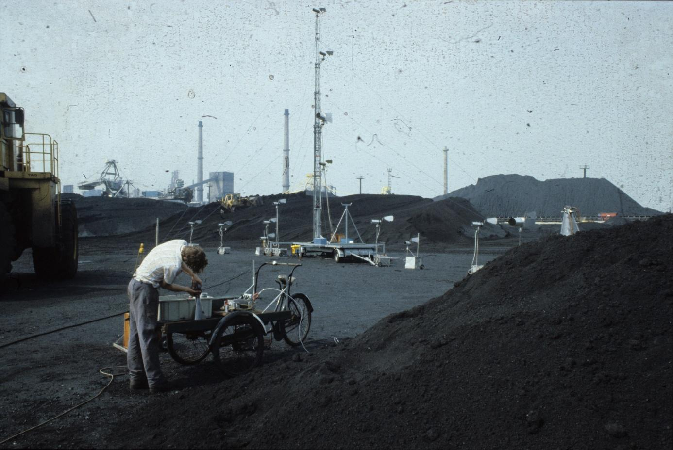 Figuur 3 Meetopstelling bij het storten van kolen In 1988 werden experimenten uitgevoerd om de stofemissie bij het storten van kolen vanaf een lopende band te onderzoeken met de zogenaamde profiler