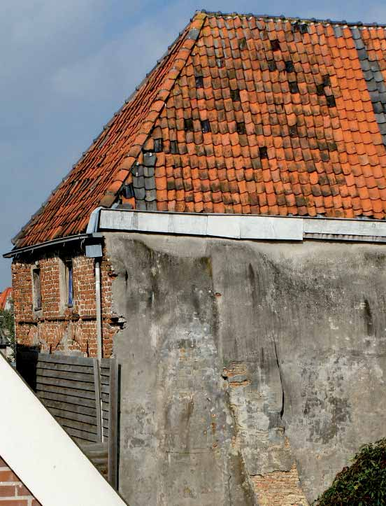 Buiten Nieuwstraat 56; Vlak boven de houten schutting zijn natuurstenen kruiskozijnen waar te