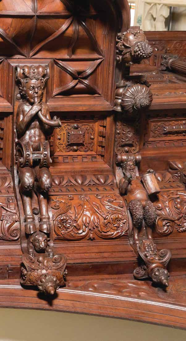 Drie saterhermen met muziekinstrumenten dragen het rugpositief. Tussen hen in ranken en het jaartal 1617, het begin van de orgelbouw.