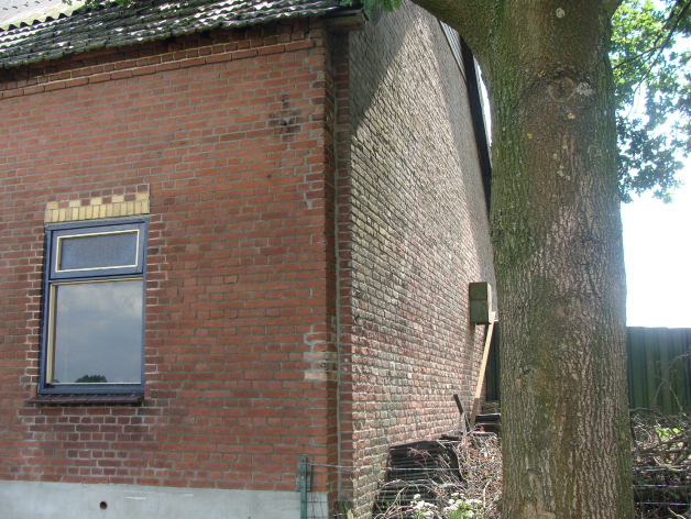 Op de plaats waar het verdwenen schuurgedeelte heeft gestaan, is een nieuwe topgevel tegen de bestaande boerderij