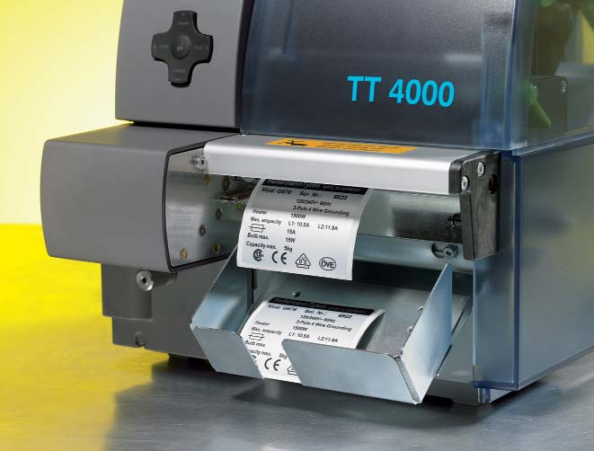 Vooral bij kleinere labels of krimpkousstukjes is dit een welkome hulp. Mes S4000 met opvangbox, aan de printer gemonteerd.