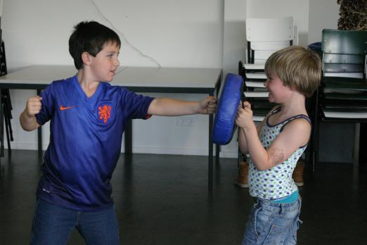 Na een warming up werden de basis stoten en houdingen van de vechtsport geleerd. Bij sommige kinderen met indrukwekkende Kung Fu kreten.