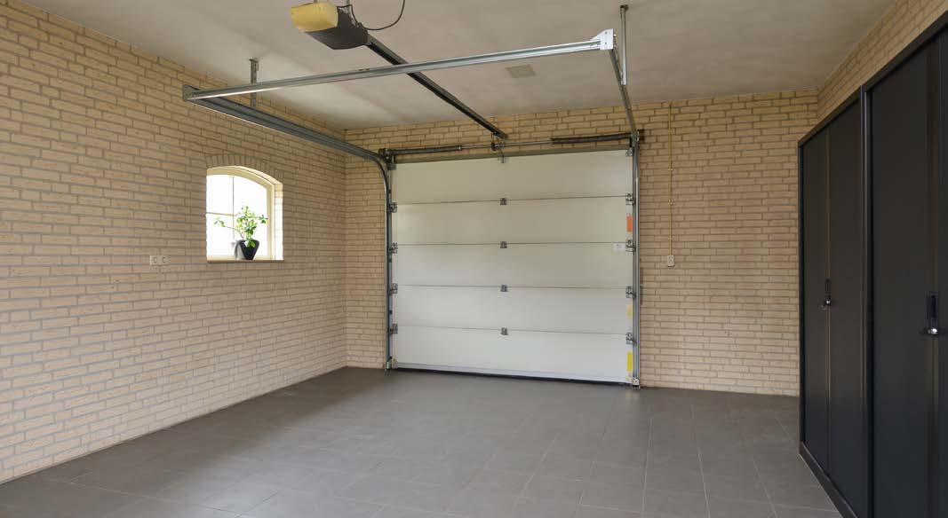 Garage In de ruime inpandige garage met elektrische sectionaaldeur zijn de cv-ketel (Remeha Calente, 2013) en de