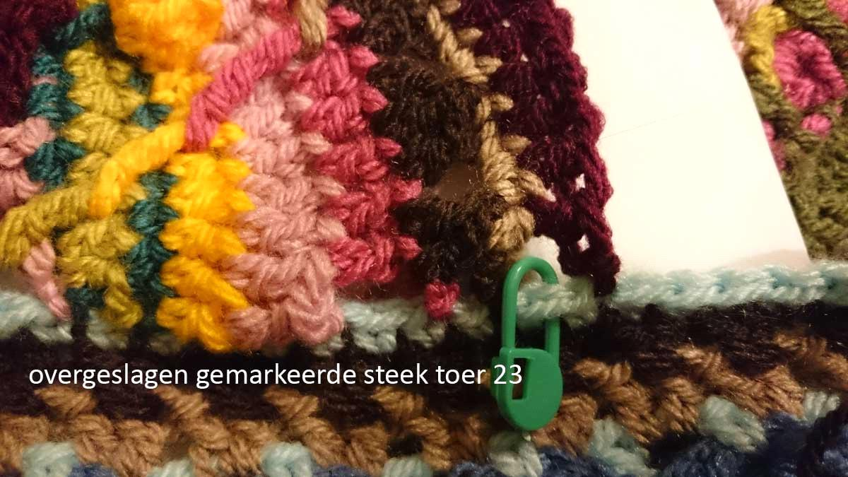 Toer 23 Sla 1 rand steek over en maak een hv in de volgende steek. Markeer de overgeslagen rand steek. Sla de eerste vaste over en maak 9 stokjes in de volgende steken.