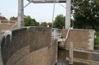 Bruggen: brugleuning en brudgek vertonen zeer veel schade, brugdek heeft veel slijtplekken. Brug sluit niet aan op rijbaan.