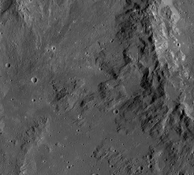Langs de hellingen zie je heldere strepen terwijl de kraterbodem breuklijnen bevat.