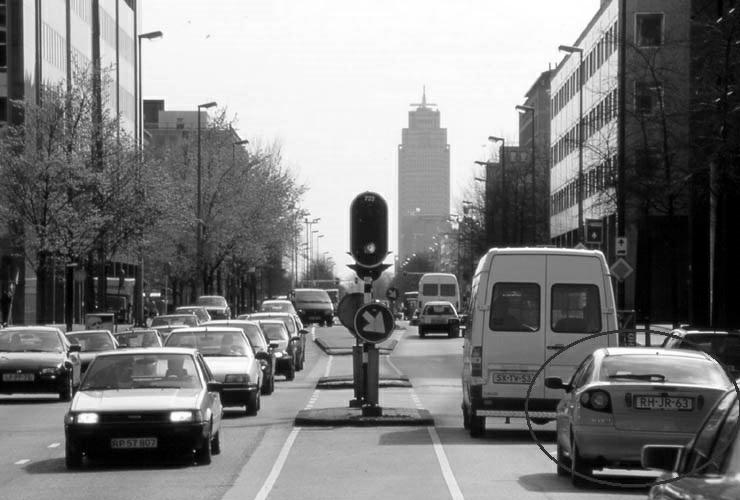 Afbeelding 9 - Drukke straat 14. U rijdt in de stad en nadert een kruispunt. U hoort sirenes maar ziet niet waar het hulpverleningsvoertuig (met zwaailicht en sirene) vandaan komt. Wat zou u doen?