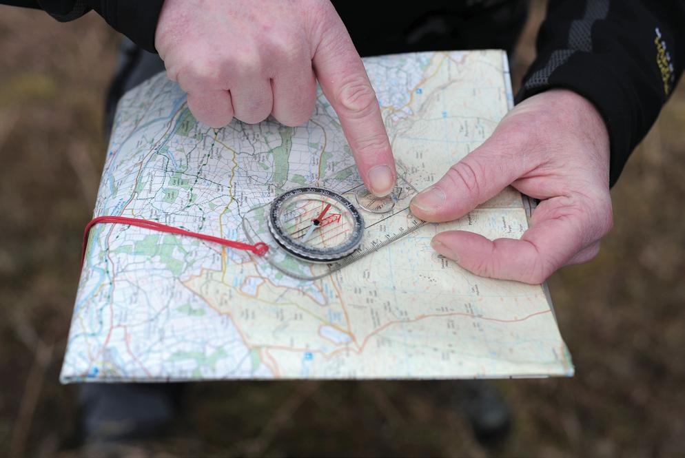 De rode pijl van een kompas wijst altijd naar het noorden. Houd het kompas horizontaal en kijk in welke richting de rode pijl wijst.