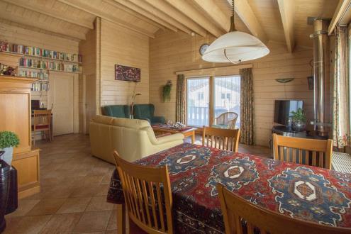 Woonkamer: De gezellige woonkamer heeft de beschikking over een houtkachel en aan de achterzijde openslaande tuindeuren die toegang bieden tot de veranda met terras.