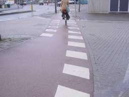 Markering op het fietspad rechtsaf ook haaietanden voor afslaand verkeer, middenmarkering op fietspad ontbreekt.