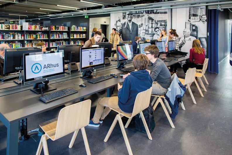 Tijdens het computercafé komen computerliefhebbers samen om elkaar te helpen met ICT-problemen. Een vrijwilliger staat klaar om te ondersteunen.