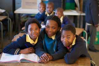 NAAR SCHOOL Het onderwijs is in Zuid-Afrika een beetje anders als in Nederland. Zo moeten alle kinderen een schooluniform dragen, met daarop het wapen van de school.