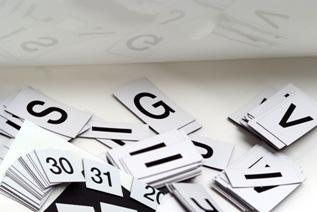 De woorden, letters, cijfers en symbolen zijn aangebracht op magnetische kunststof plaatjes met een witte achtergrond.