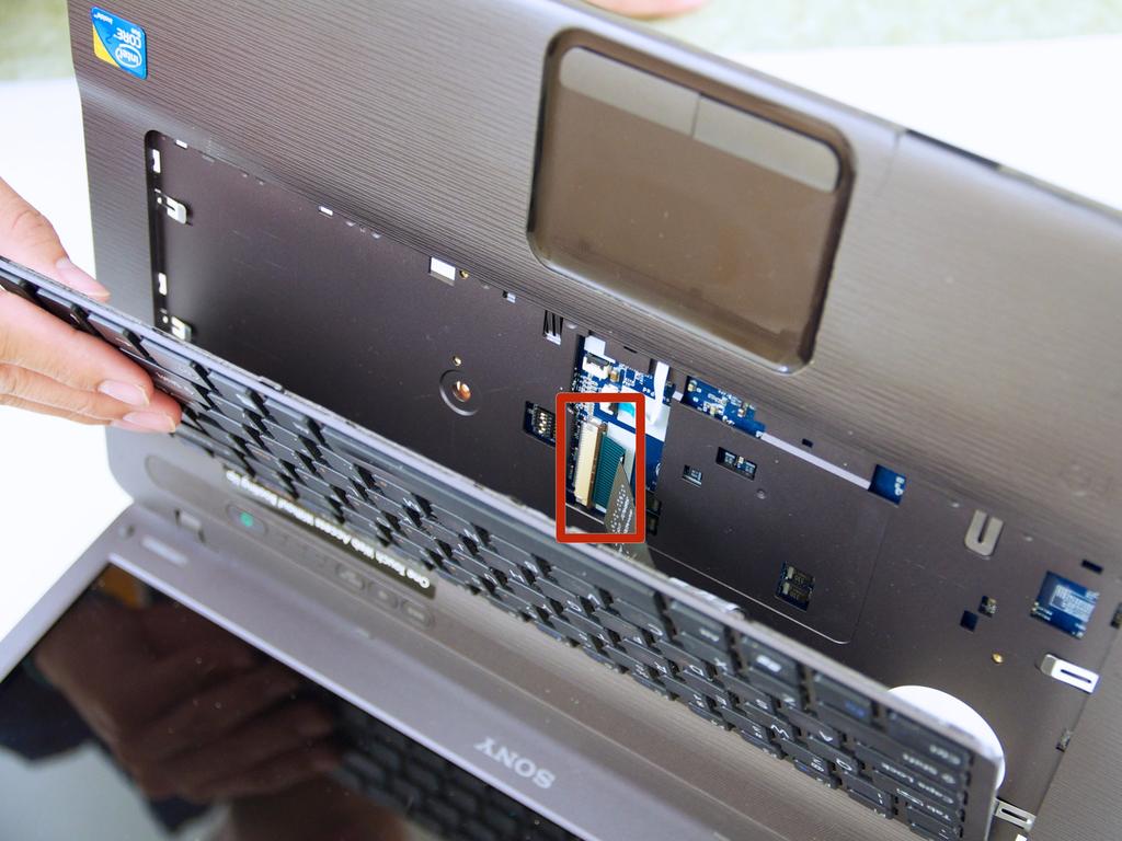 Er is een lintkabel bevestigen van het toetsenbord naar de achterkant van het moederbord.